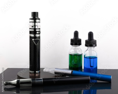 Electronic cigarettes and glass bottles with vape liquid on white background