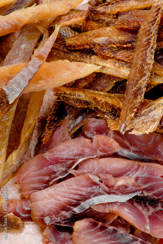 Beer Snack. Dried fish close upAssorted beer snacks: fried mussels, dried fish, french fries, cheese sticks on kraft paper on a tray on a concrete background in a beautiful composition with vegetables Beer Snack. Dried fish close upAssorted beer snacks: fried mussels, dried fish, french fries, cheese sticks on kraft paper on a tray on a concrete background in a beautiful composition with vegetables