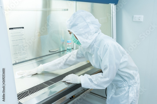 Tableau sur toile A scientist in sterile coverall gown using alcohol 70% and cleanroom wipes for cleaning Biological safety cabinet(BSC