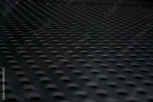 Gray monophonic background with big quantity of holes in a metal plate. Surface. Texture.