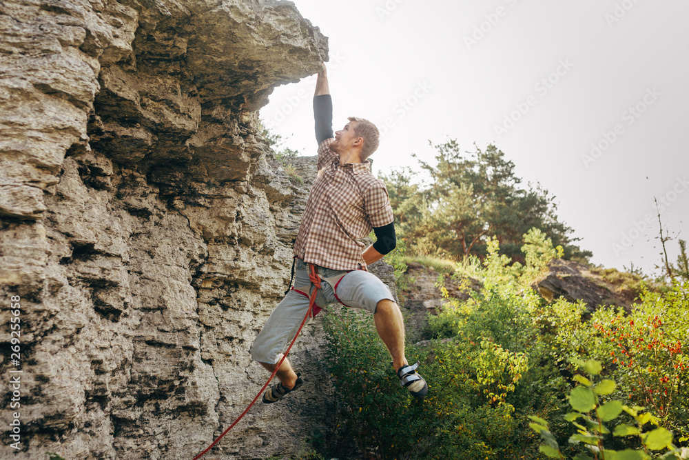 Brave young man climbs the cliff