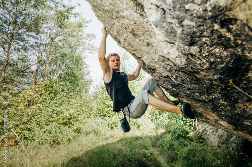 Male rock climber hanging on the cliff