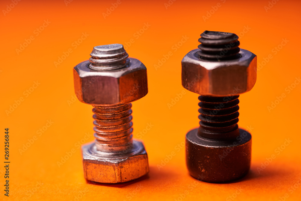 Bolted connecting elements on orange background close-up Bolted connecting elements on orange background close-up
