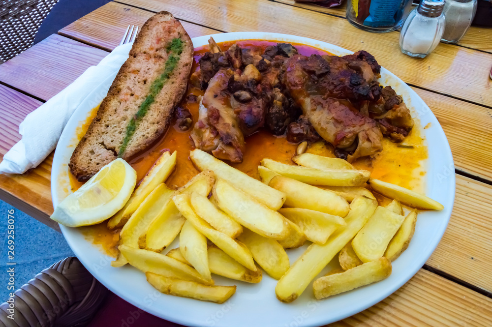 Plate of pig's feet with grapes with a slice of bread Plate of pig's feet with grapes with a slice of bread