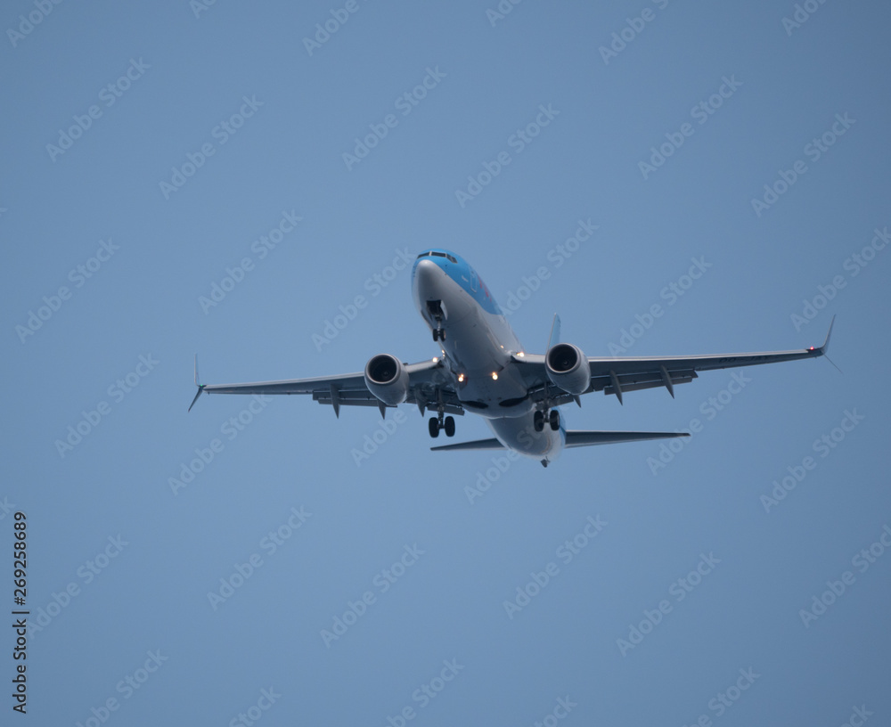 Big passenger airplane flying in blue sky