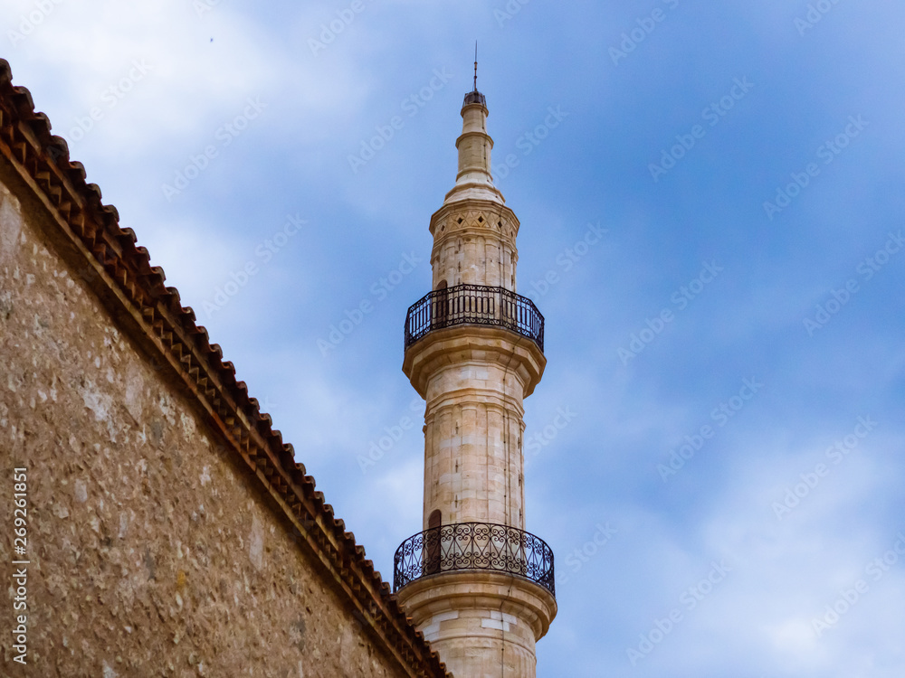 Minaret of old mosque towering over the wall in the old part of Rethymno - Crete, Greece