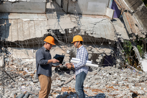 Demolition control supervisor and contractor discussing on demolish building.