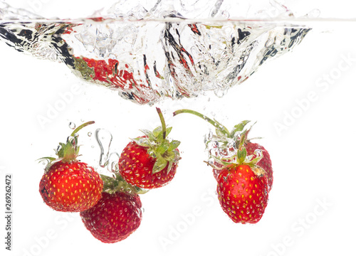 Fototapeta Naklejka Na Ścianę i Meble -  Red fresh strawberries thrown into the water, under water. Spat and splash