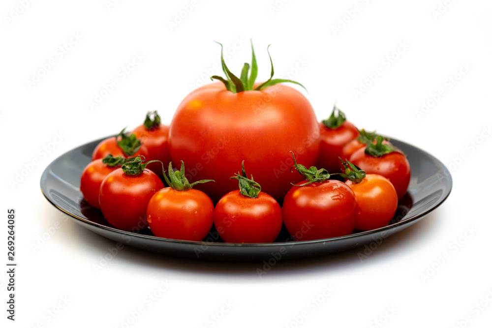 Tomatoes in a black plate isolated on white background. Composition of red tomatoes on a white background. Place for text Tomatoes in a black plate isolated on white background. Composition of red tomatoes on a white background. Place for text