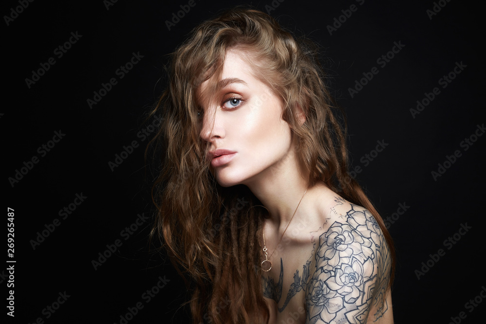 Sexy Young Woman with Tattoo. Beautiful Girl with curls