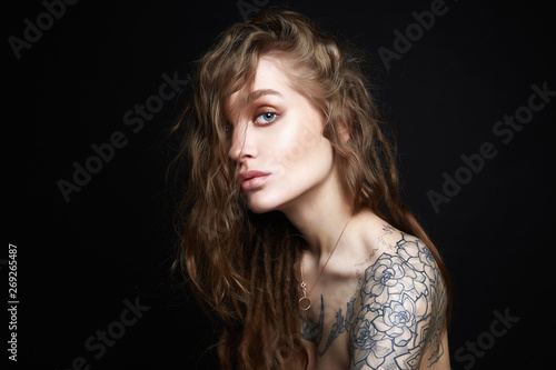 Sexy Young Woman with Tattoo. Beautiful Girl with curls