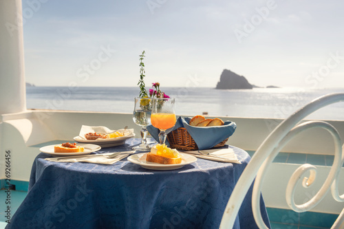 typical Sicilian breakfast with homemade jams and fresh orange juice and view from the island of Panarea