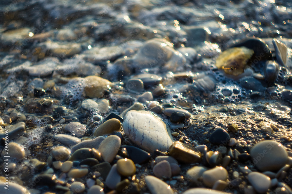 pebble stones on the sea beach, the rolling waves of the sea with foam pebble stones on the sea beach, the rolling waves of the sea with foam