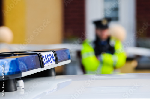 Garda Siochana Irish police officer behind a car photo