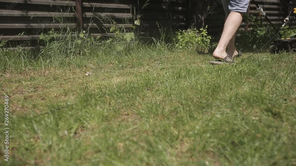 fat bald man barefoot Topless mows lawn yellow lawn mower. close up fat bald man barefoot Topless mows lawn yellow lawn mower. close up