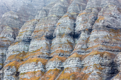 Billon year old jagged rock formations with different green moss photo