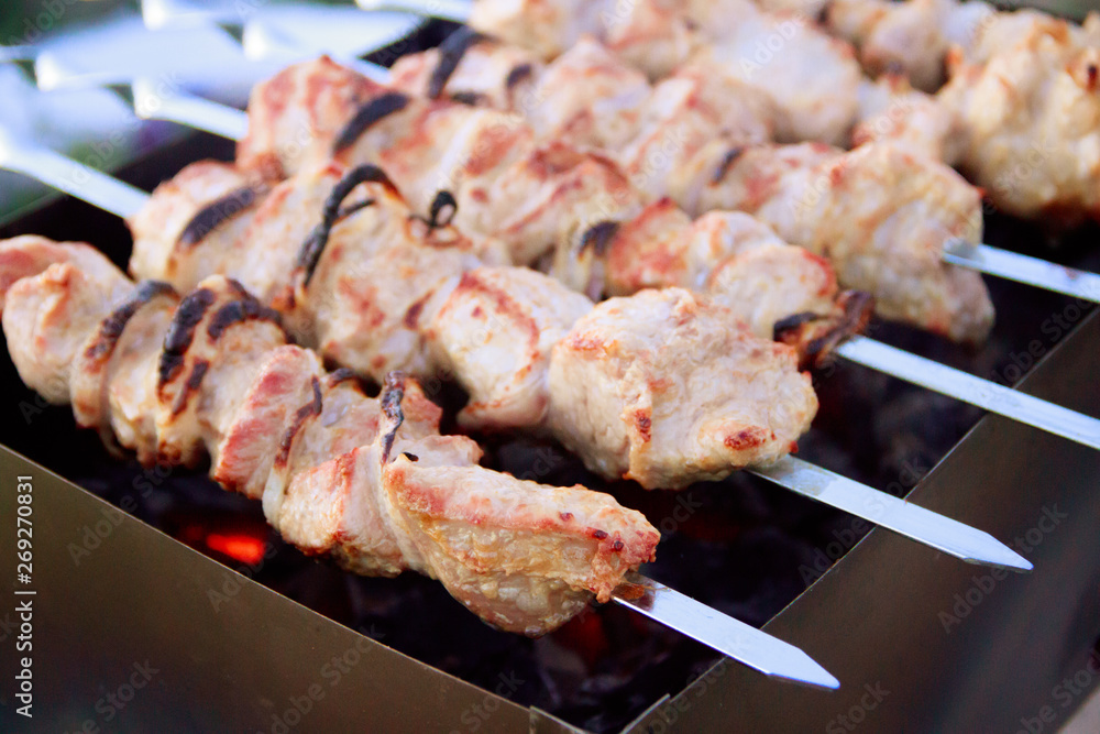 Skewers on skewers on the grill. Grilled meat on the coals. Marinated meat.