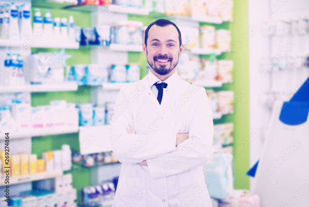 Male pharmacist displaying assortment of drugs