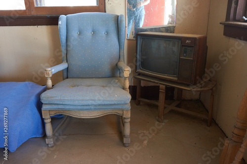 KERN COUNTY, CALIFORNIA/UNITED STATES – SEPTEMBER 3, 2016: A vintage TV and chair at Robbers Roost, a ghost town and roadside attraction, Kern County California.