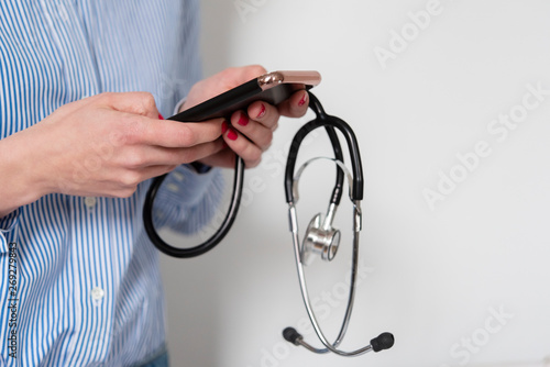 Doctor holding stethoscope and smart phone photo