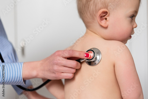 Paediatrician using stethoscope on girl photo