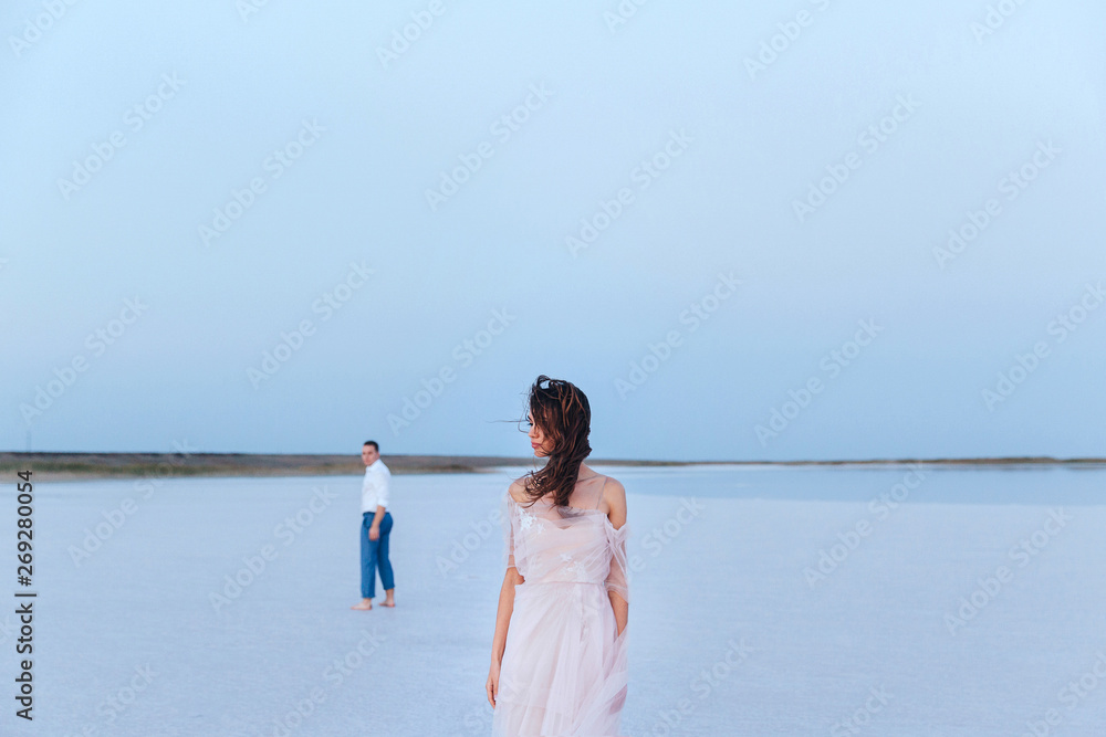 beautiful young newlyweds on the sea shore, the groom looked around at the bride, back and front view. beautiful young newlyweds on the sea shore, the groom looked around at the bride, back and front view.