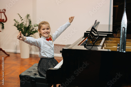 satisfied little girl play piano