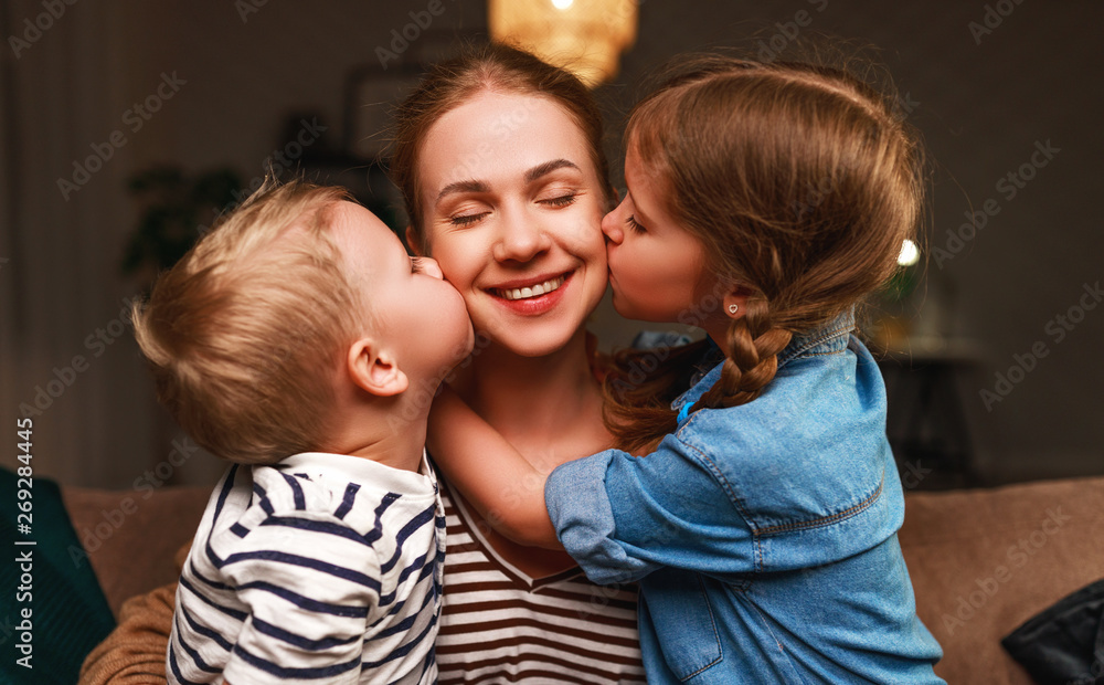 Happy family! Children kisses moms evening before bedtime