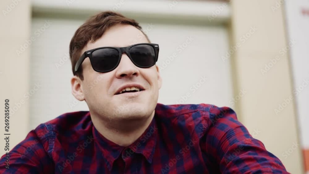 City Portrait of a young man. A man on a Sunny day on a city street, wearing sunglasses City Portrait of a young man. A man on a Sunny day on a city street, wearing sunglasses