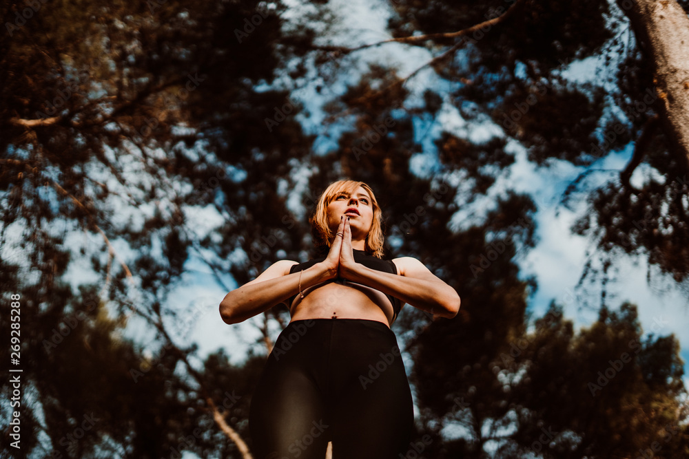 .Young and pretty woman doing yoga outdoors in the middle of nature a nice spring afternoon. Relaxation, deep breathing and calm. Lifestyle. .Young and pretty woman doing yoga outdoors in the middle of nature a nice spring afternoon. Relaxation, deep breathing and calm. Lifestyle.