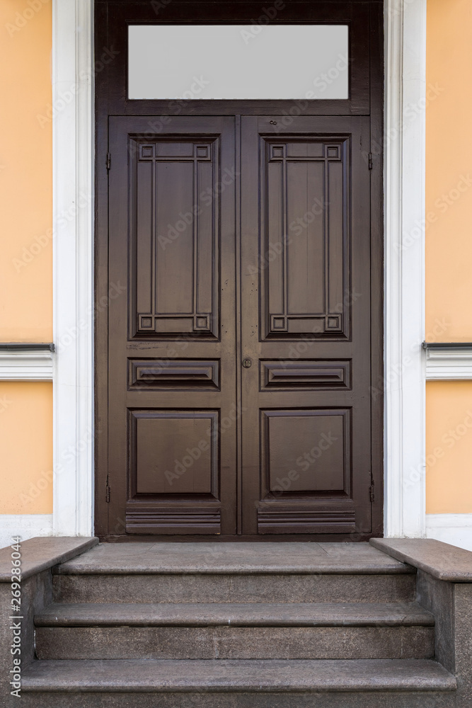brown closed wooden door with window and concrete steps brown closed wooden door with window and concrete steps