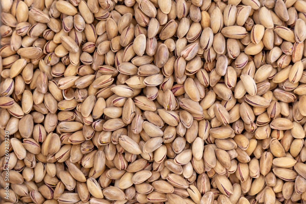 Pistachios background closeup on a huge pile of dried Iran nuts. Pistachios background closeup on a huge pile of dried Iran nuts.
