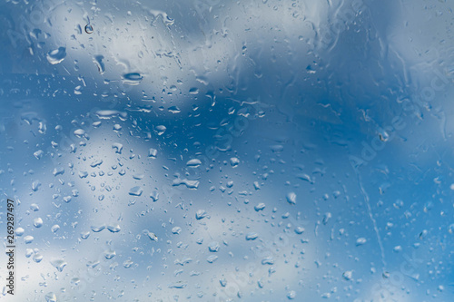 raindrops on a window a blue sky of a cloud.