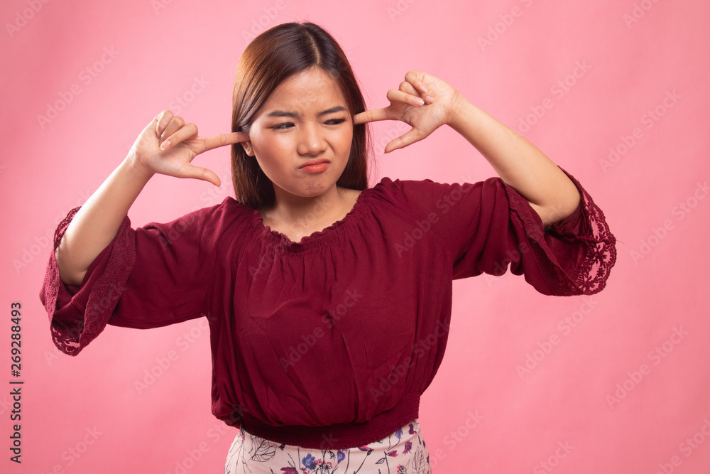 Young Asian woman block both ears with fingers. Young Asian woman block both ears with fingers.