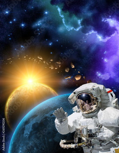 Astronaut in space suit in the outer space with the sunrise on planet and asteroids. Elements of this image furnished by NASA.