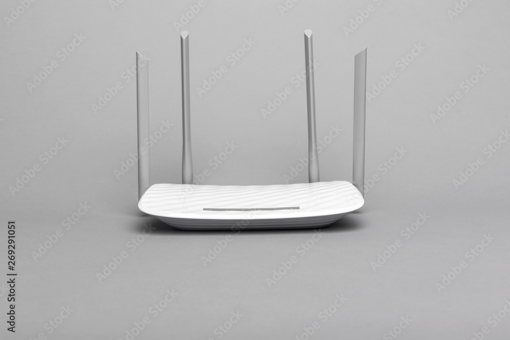 White modern Wi-Fi router with four antennas on a gray background. - obrazy, fototapety, plakaty 
