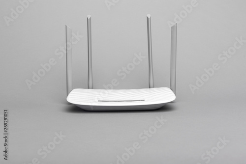 White modern Wi-Fi router with four antennas on a gray background. photo