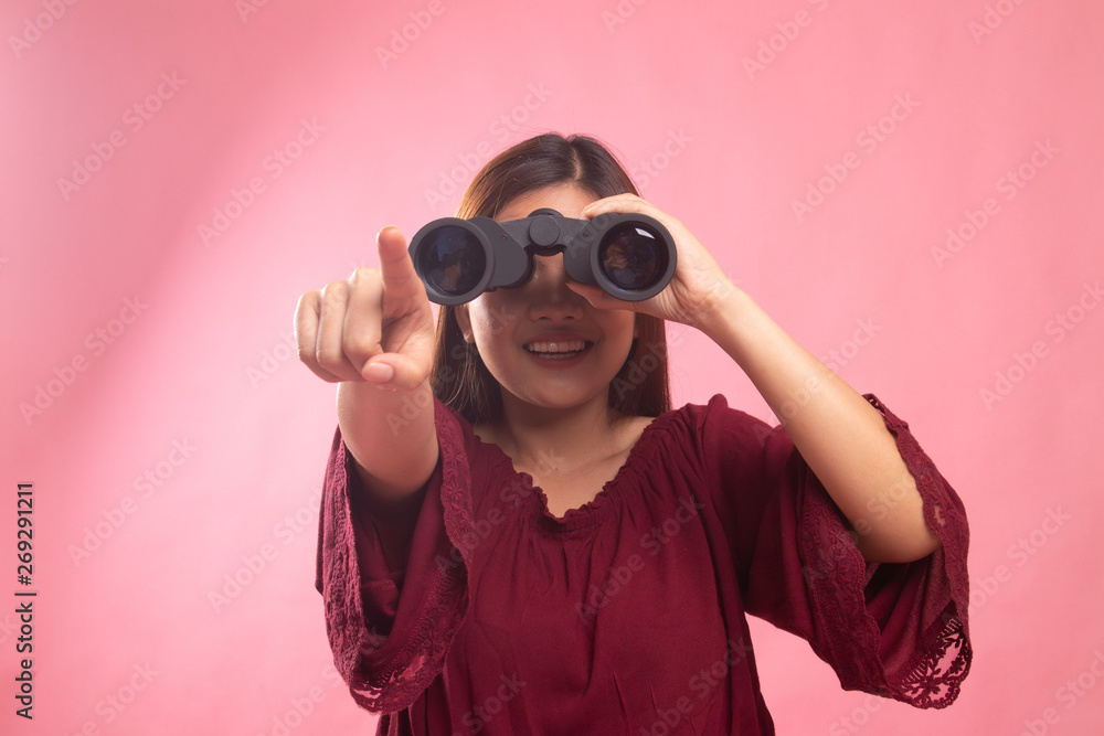 Young Asian woman point and look with binoculars. Young Asian woman point and look with binoculars.