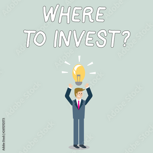 Word writing text Where To Invest Question. Business photo showcasing asking about where put money into financial schemes or shares Businessman Standing Raising Arms Upward with Lighted Bulb Icon on
