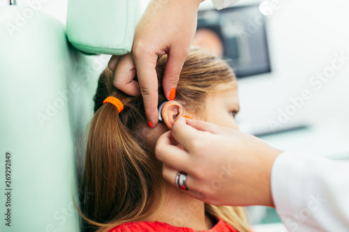 Wallpaper Mural Young girl at medical examination or hearing aid checkup in otolaryngologist's office Torontodigital.ca