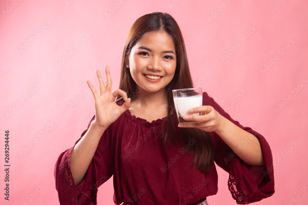 Healthy Asian woman drinking a glass of milk show OK sign. Healthy Asian woman drinking a glass of milk show OK sign.