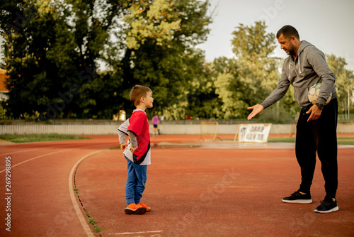 A son and a father are practicing on the court