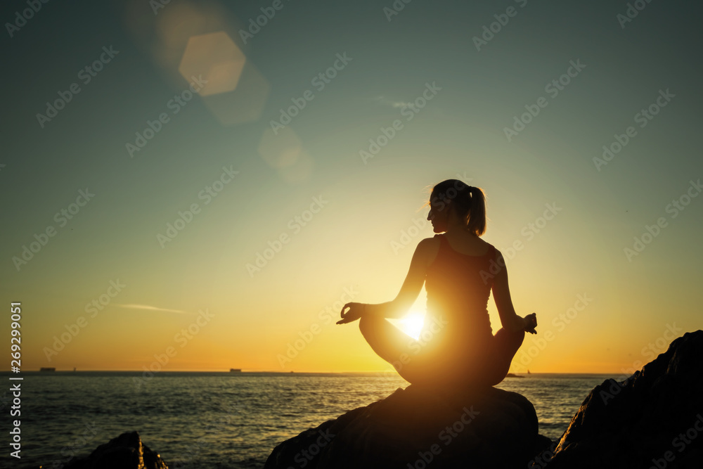 Yoga silhouette young woman on the beach amazing sunset..