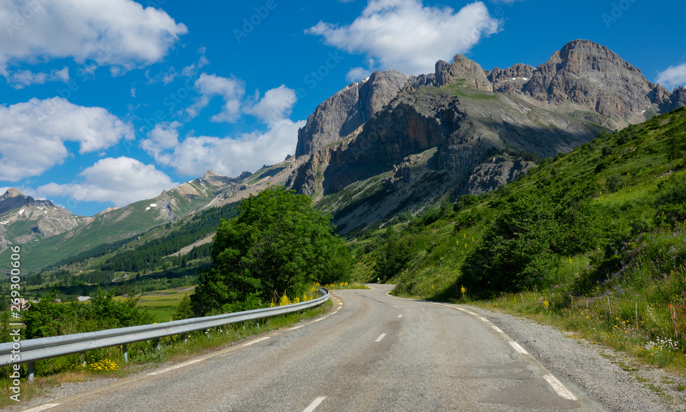 Spectacular nature surrounds the empty asphalt road in the French countryside.