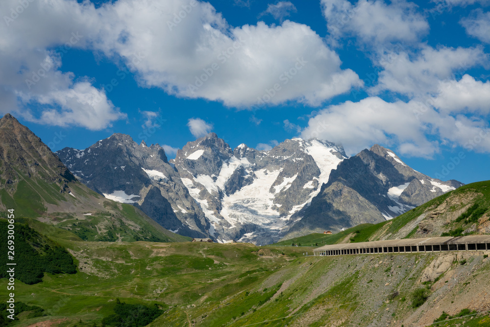 AERIAL: Tunnel crossing the valley leads towards the spectacular rocky mountains