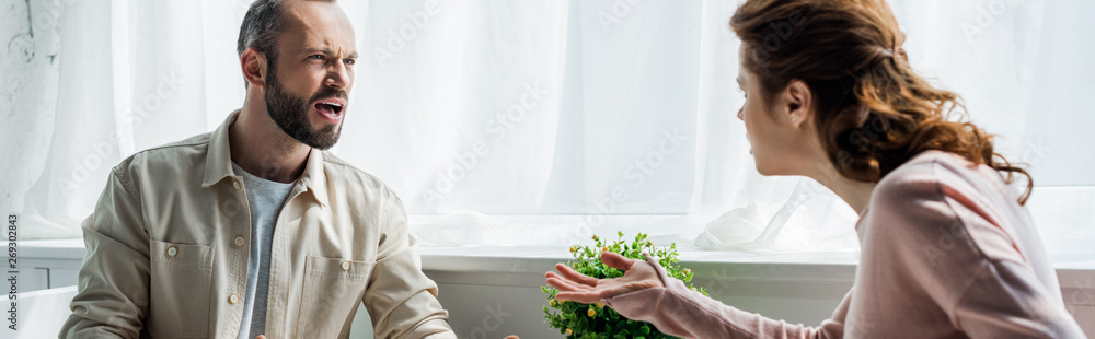panoramic shot of angry man screaming and looking at woman panoramic shot of angry man screaming and looking at woman