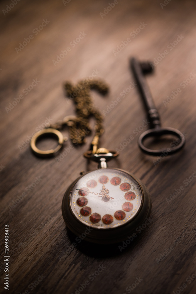 The key of time, pocket watch and rusty key