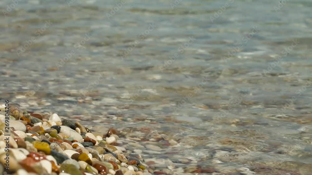waves roll on the seashore with pebbles. beautiful blurred highlights and bokeh on the beach with sea waves, pebbles and sunbeam waves roll on the seashore with pebbles. beautiful blurred highlights and bokeh on the beach with sea waves, pebbles and sunbeam