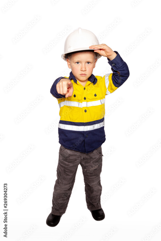 Young blond caucasian boy pointing out, fierce angry look role playing a frustrated construction worker supervisor in a yellow and blue hi-viz shirt, boots, white hard hat, minus hammer and tape Young blond caucasian boy pointing out, fierce angry look role playing a frustrated construction worker supervisor in a yellow and blue hi-viz shirt, boots, white hard hat, minus hammer and tape