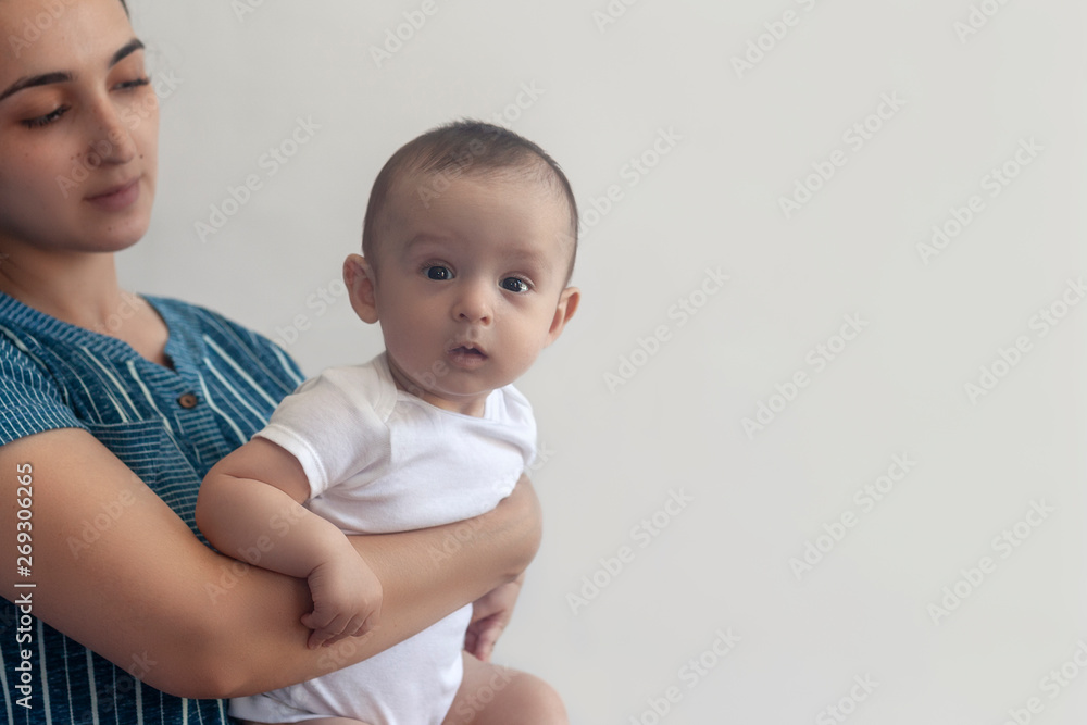 Mother and baby. Mom holding her 6 months baby boy. Beautiful baby boy of six months in his mother's hands. Young middle eastern mother holding in her arms her little son Mother and baby. Mom holding her 6 months baby boy. Beautiful baby boy of six months in his mother's hands. Young middle eastern mother holding in her arms her little son